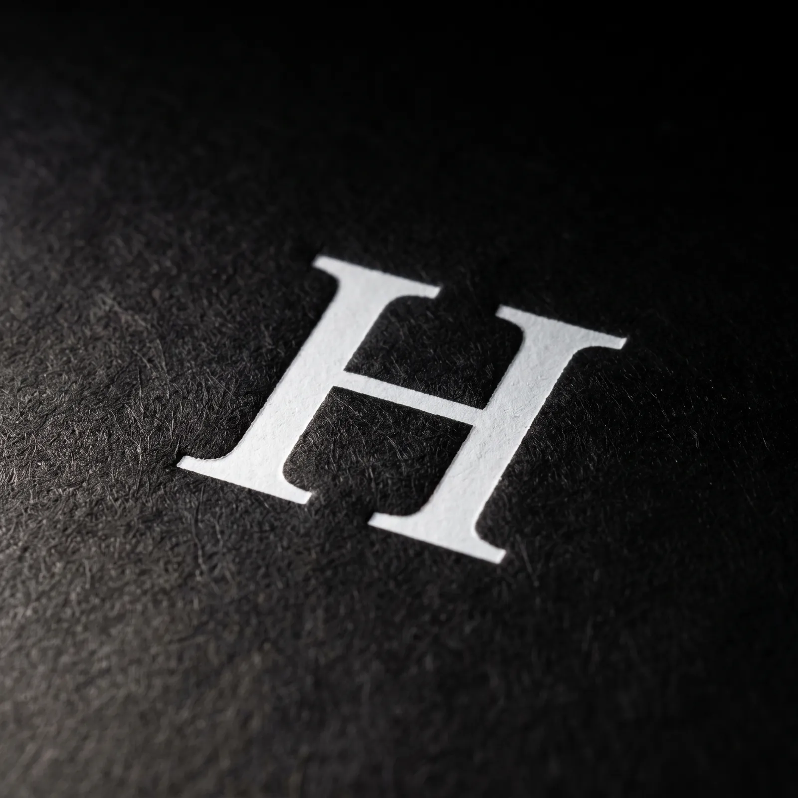 White pigment foil letter stamped on black uncoated board