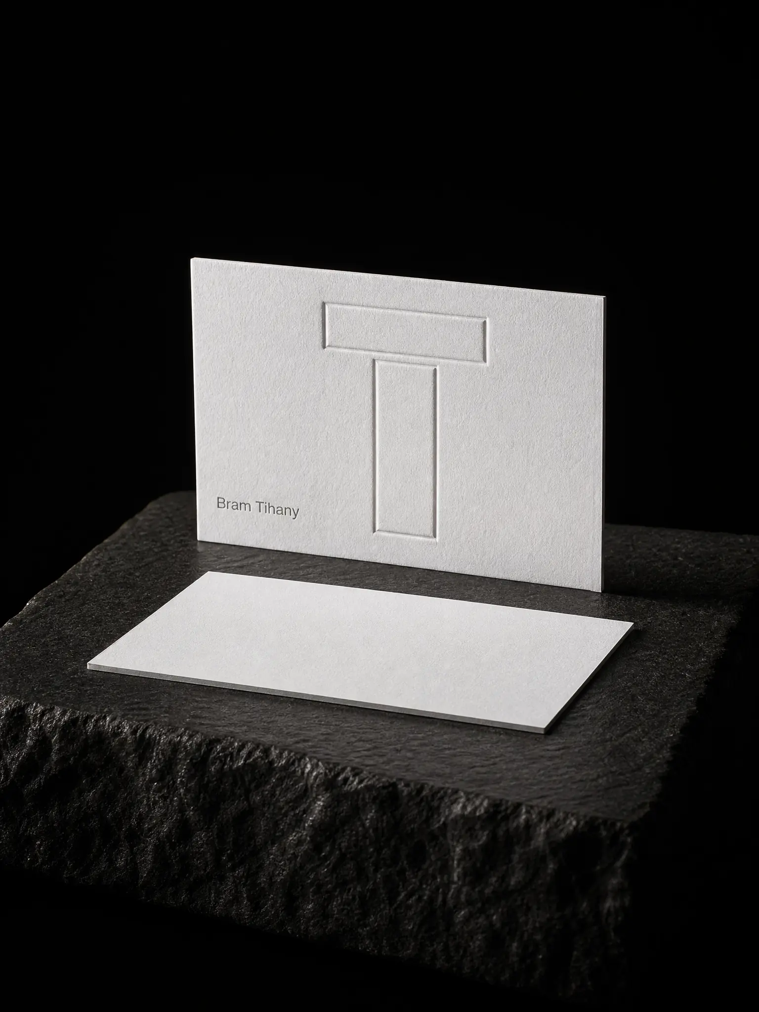 Bram Tihany business card: a two-level blind-embossed monogram and a grey name on 48pt cotton