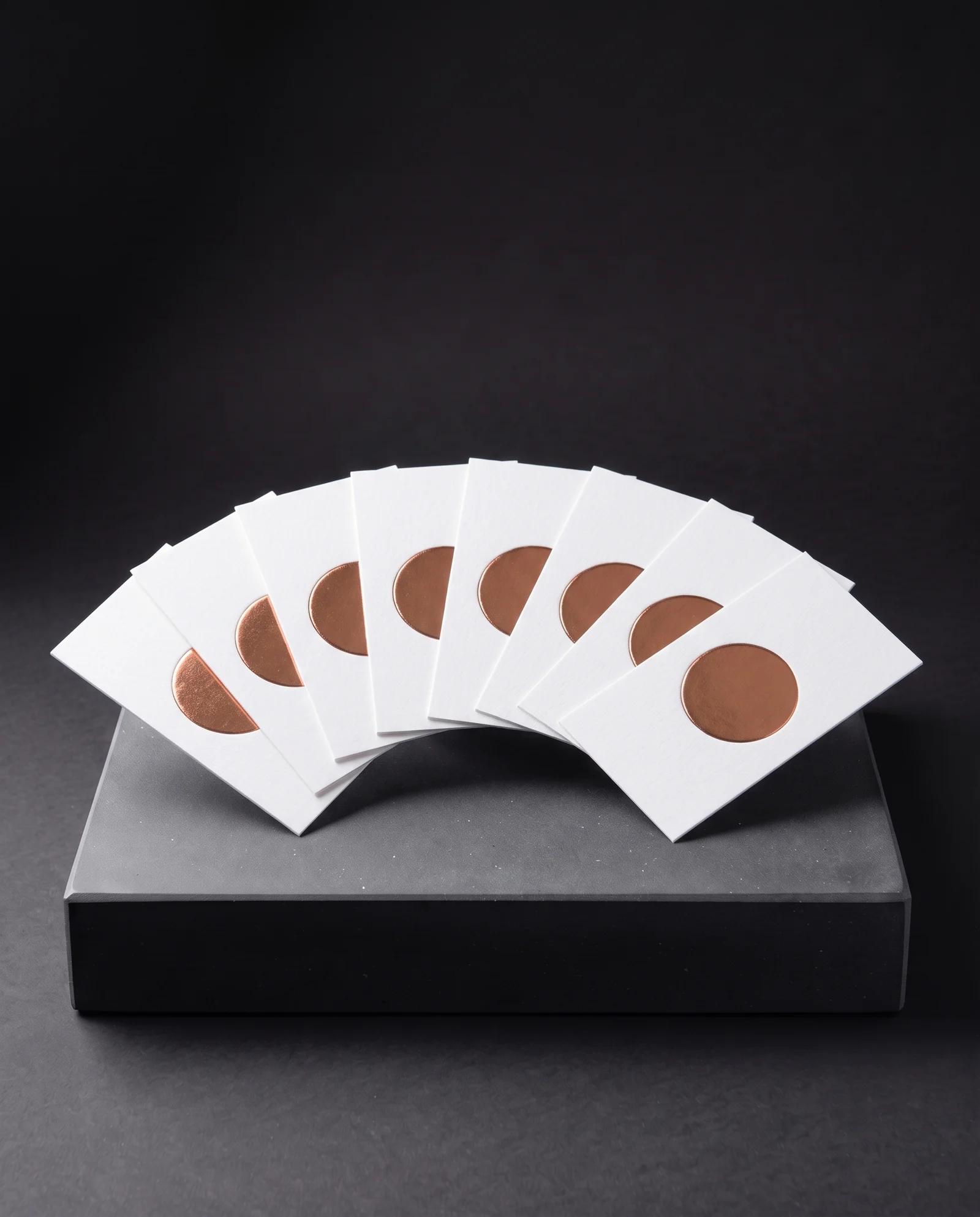 A fan of cards, each with the identical copper foil emboss.