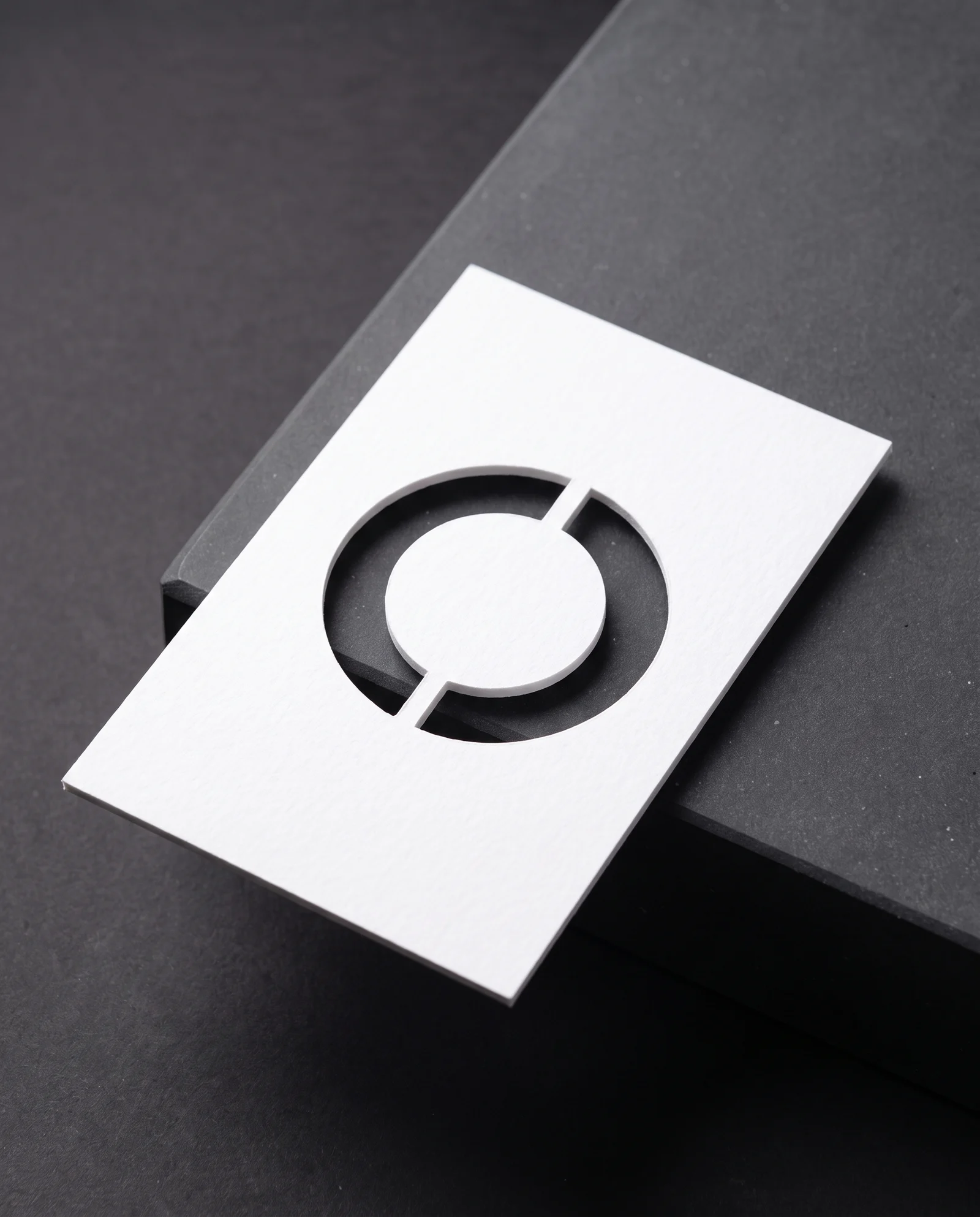 A die-cut ring whose centre is held in place by two small bridges.