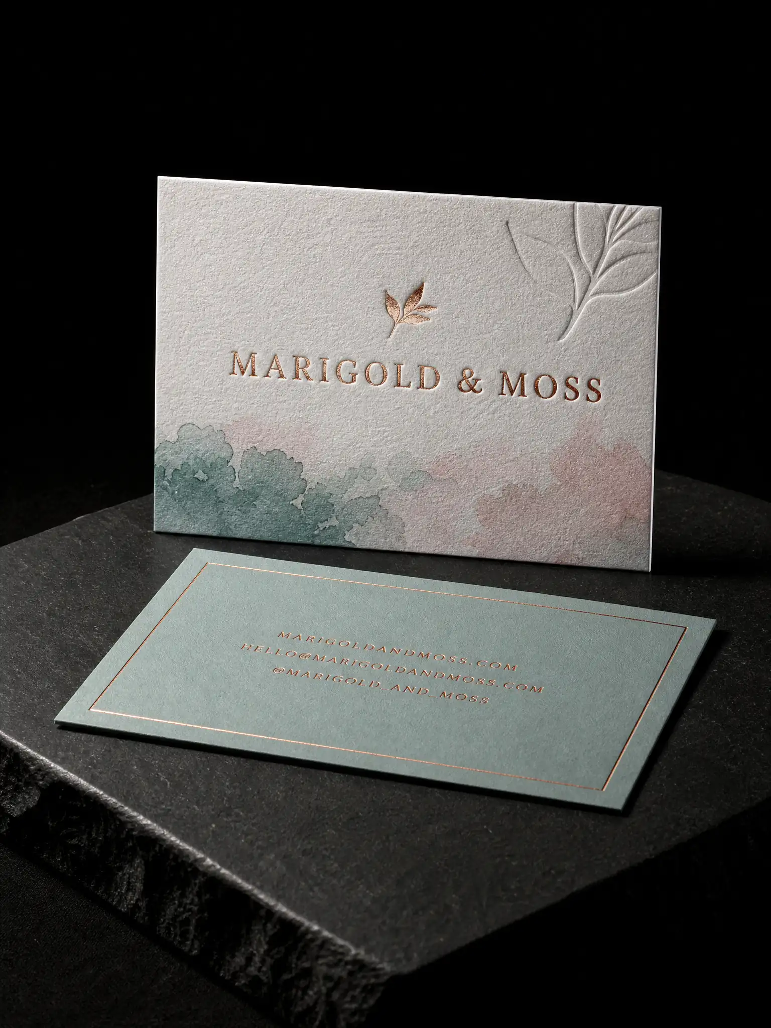 Marigold & Moss business card: copper foil leaf and a blind deboss of the same mark on thick cotton