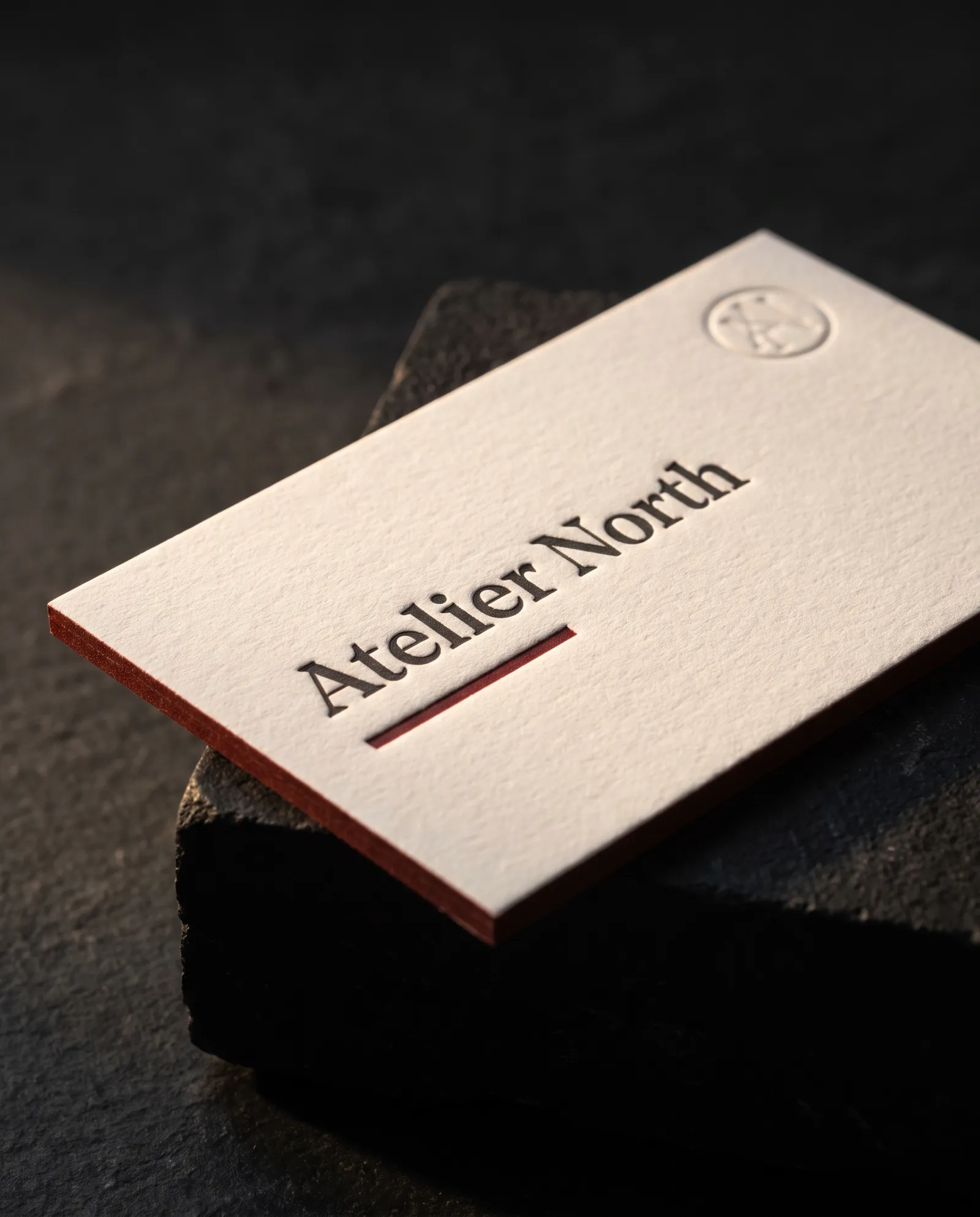 Two-color letterpress business card with a blind debossed monogram and a painted edge on 48pt cotton