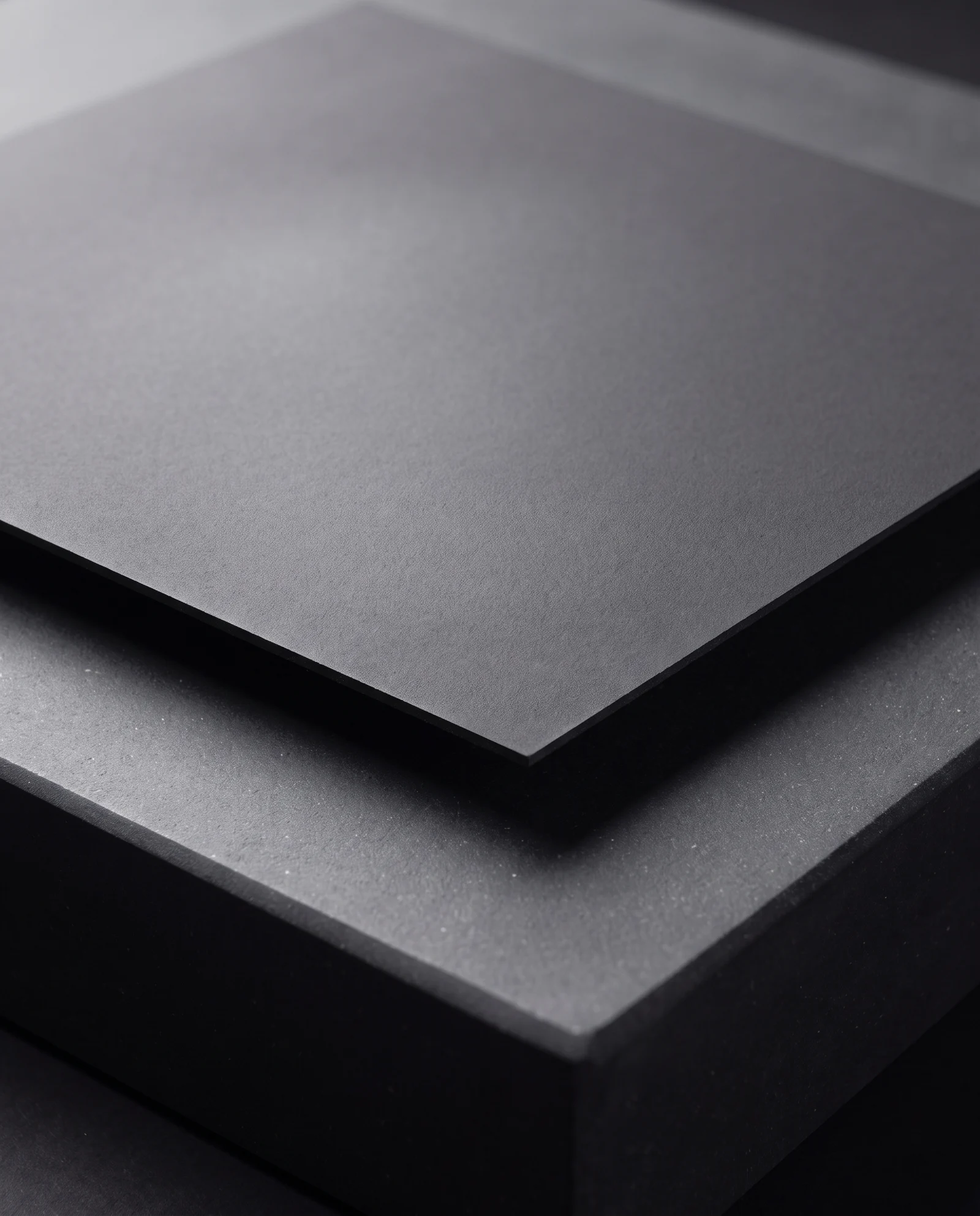 Macro of a smooth charcoal soft-touch laminated surface.