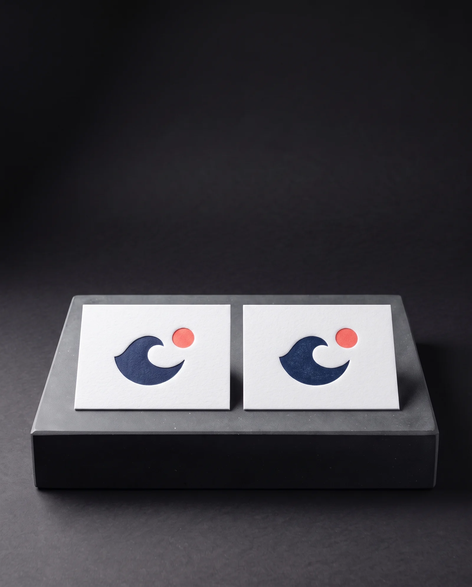 Two-colour letterpress in navy and coral on white cotton.