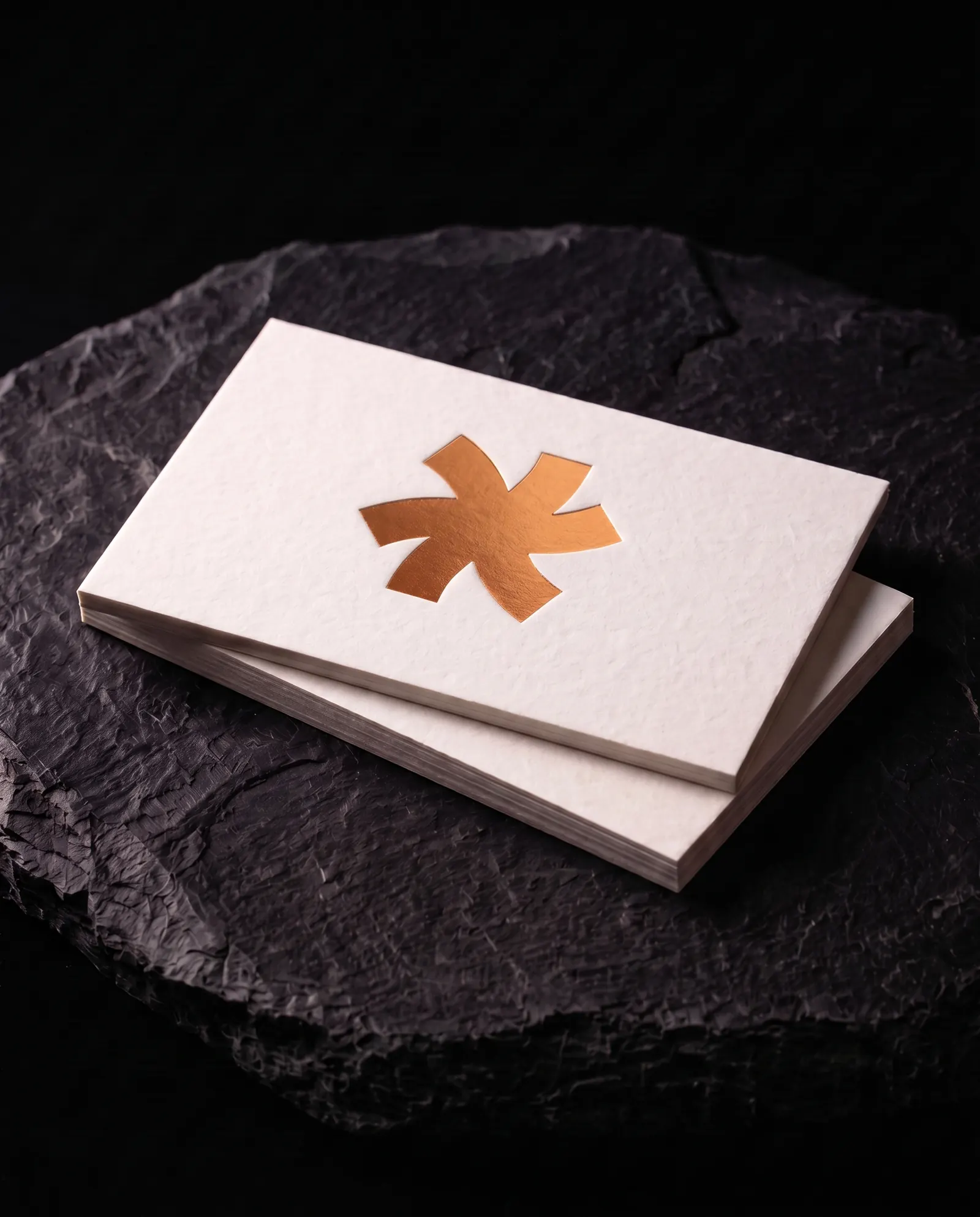 Copper hot foil business card on 32pt white cotton stock: the Print Peppermint mark stamped in copper foil, on a black slate plinth