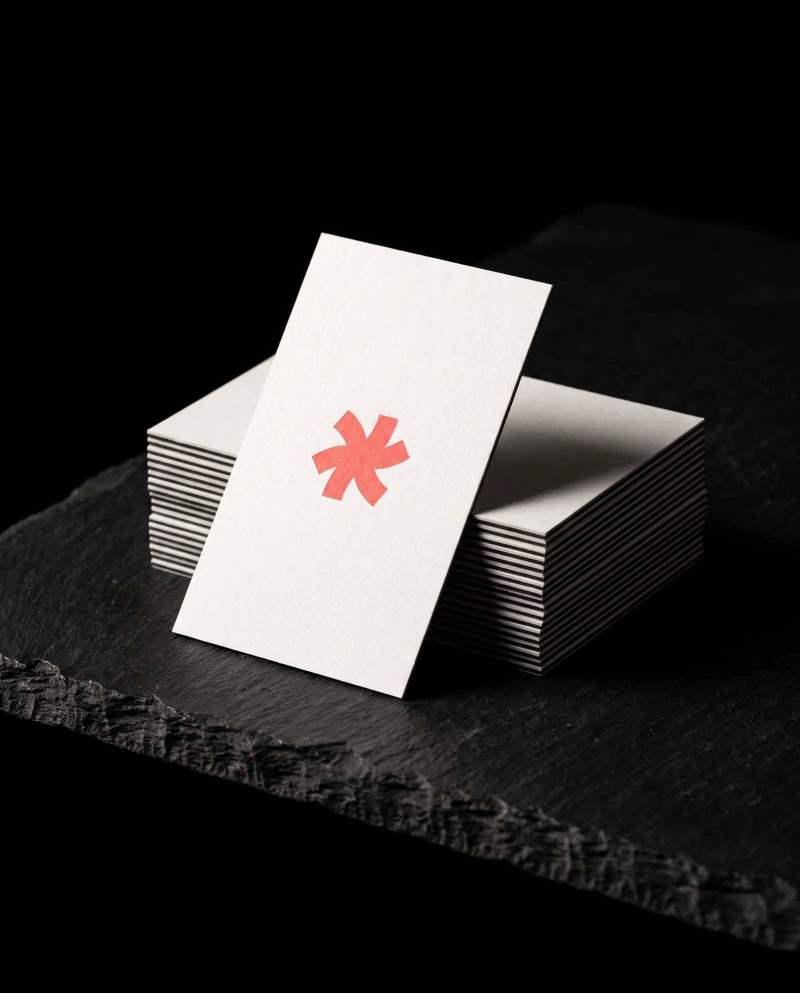 Edge of a triplex business card stack showing a black core between white plies