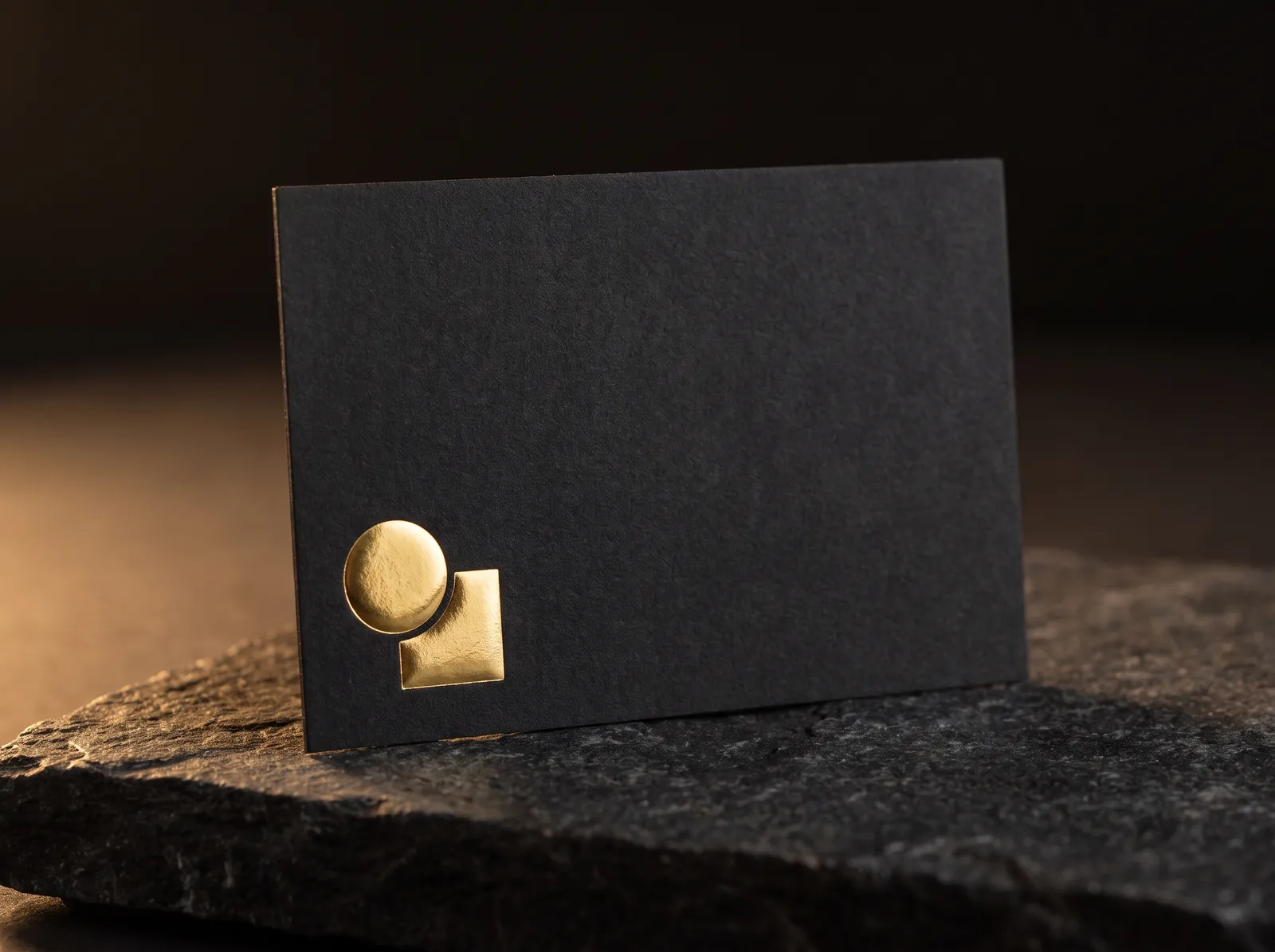 Raised gold foil standing proud of a matte soft touch business card, side light showing the dome