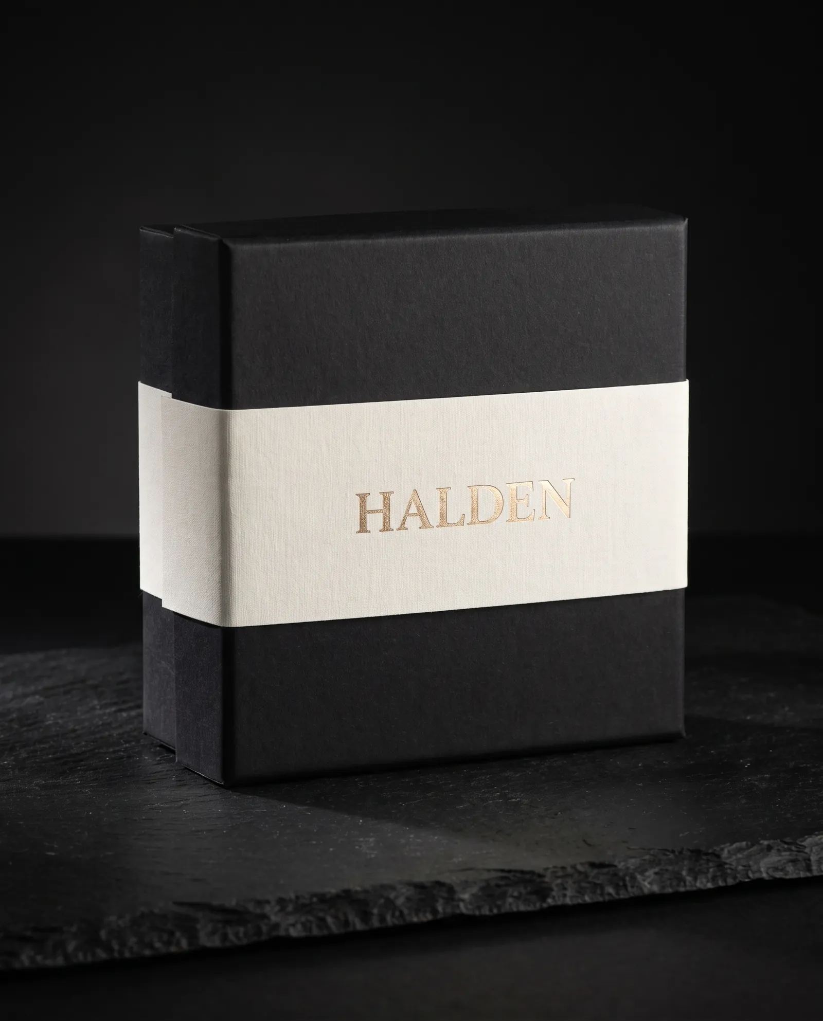 A plain black stock box made custom with an ivory cotton belly band stamped in gold foil