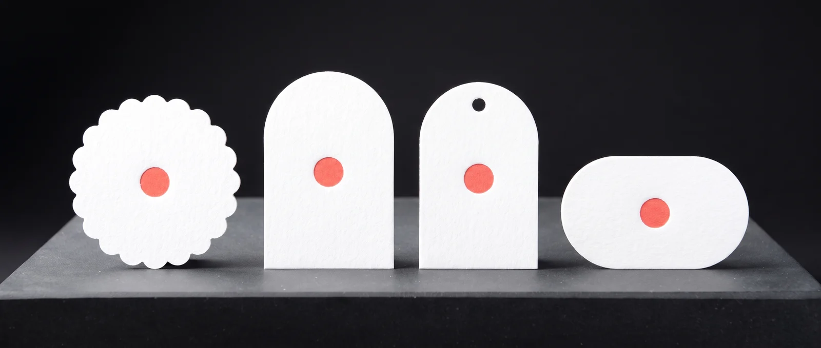 Four custom die-cut shapes in thick white cotton: scallop, arch, tag and oval.