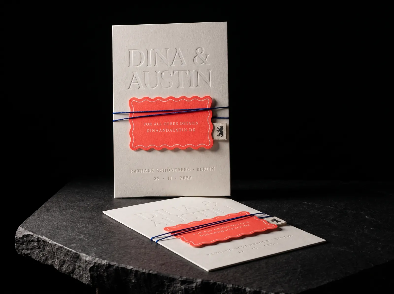 Letterpress cotton wedding invitation with a coral wavy-edge details card tied with cotton thread