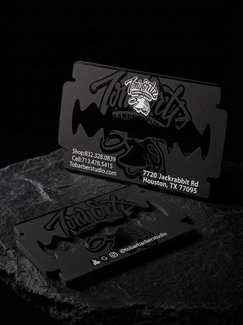 Razor-blade-shaped die-cut business card for a Houston barber, matte black with a gloss script logo