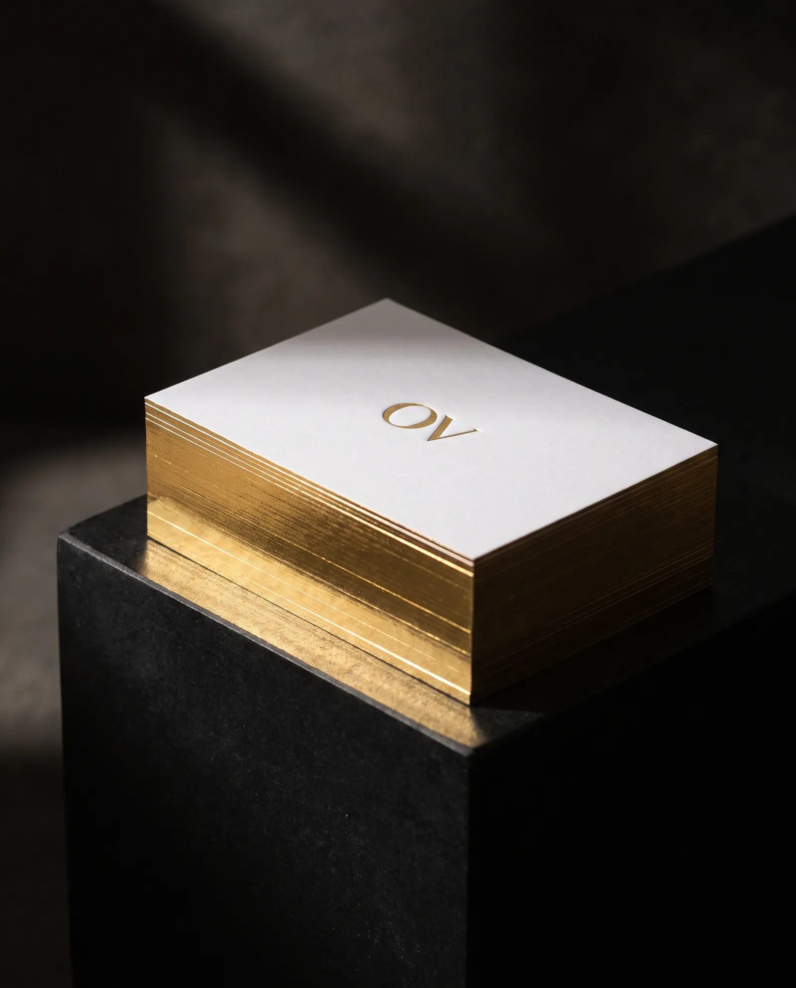 Stack of 48pt white business cards with mirror gold gilded edges and gold foil monogram