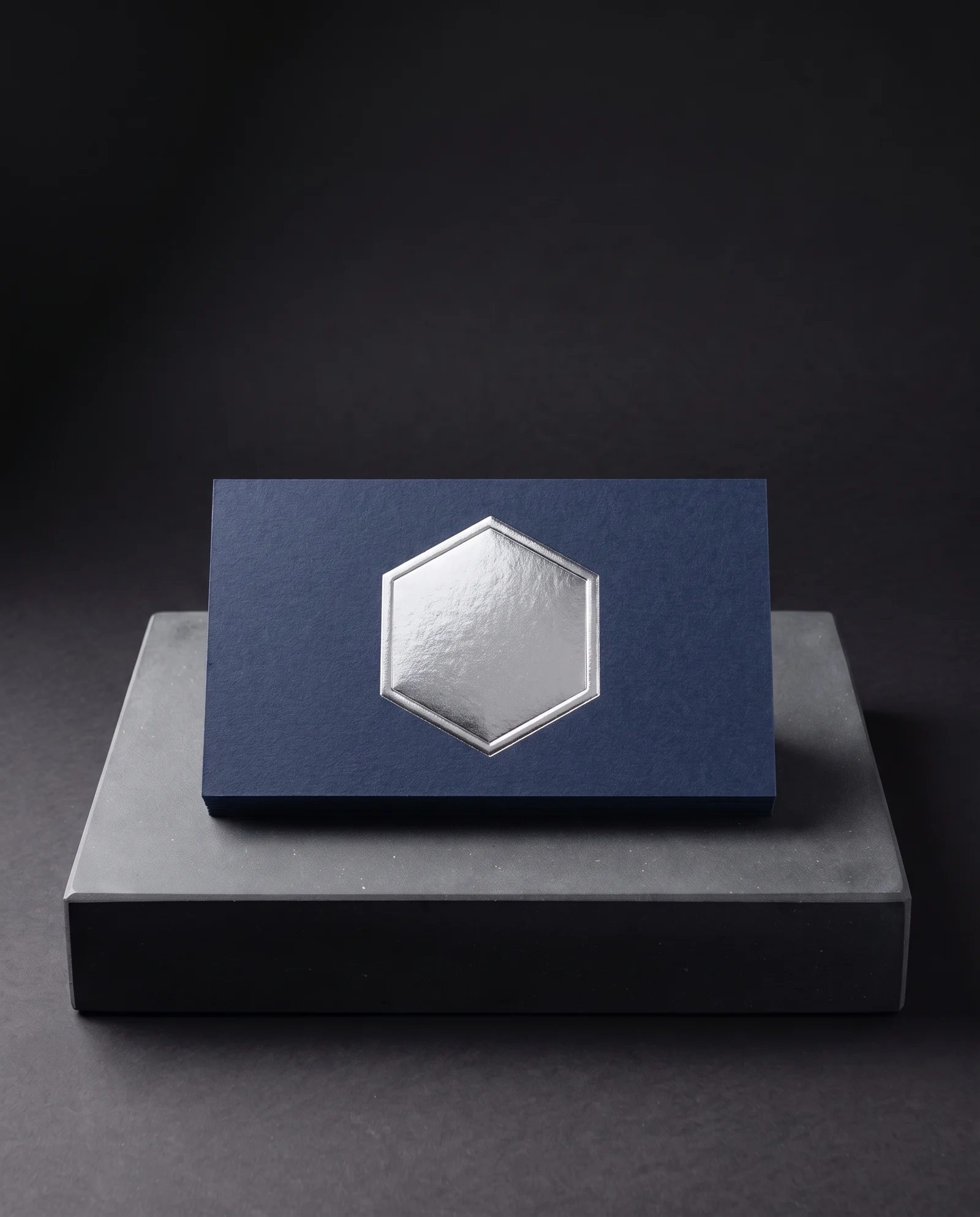 Silver foil embossed above navy colour-through card.