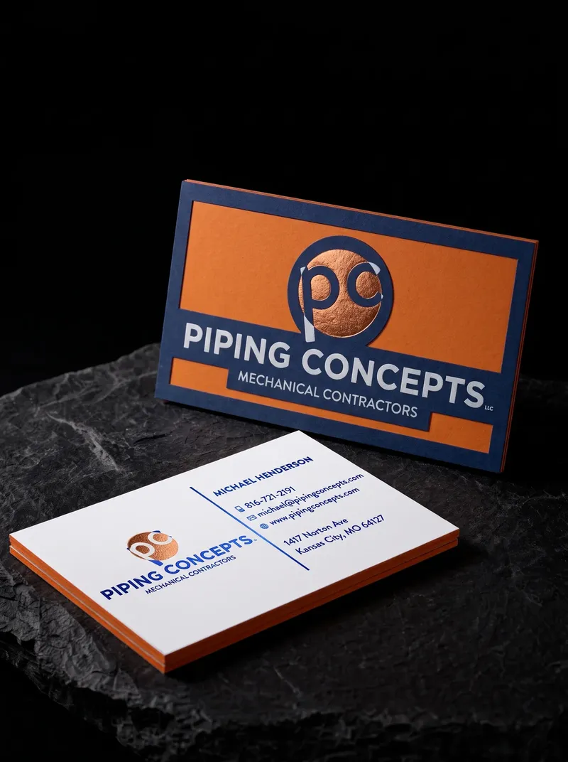 Three-layer contractor business card with an orange middle layer showing on every edge and copper foil on blue