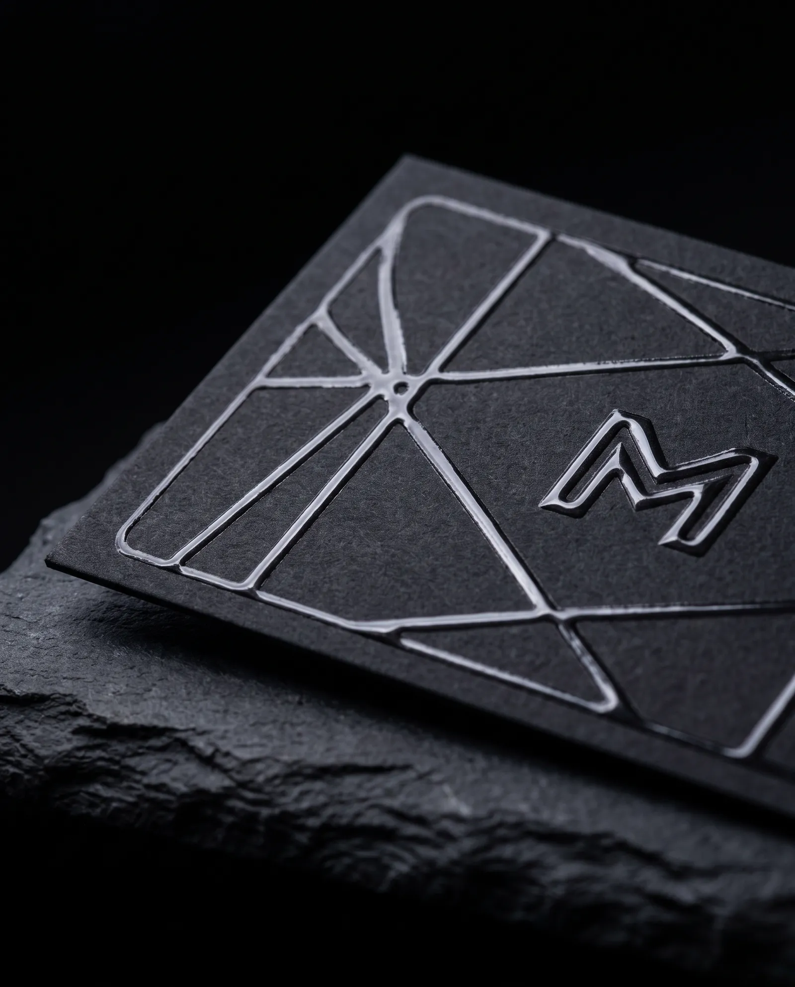 Charcoal soft touch business card with a raised clear spot UV line pattern