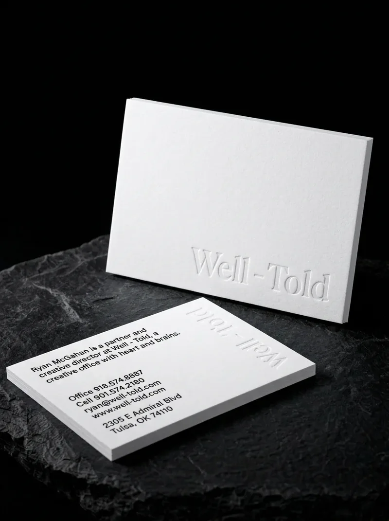 Minimalist business card with the agency name blind embossed on a blank white cotton face