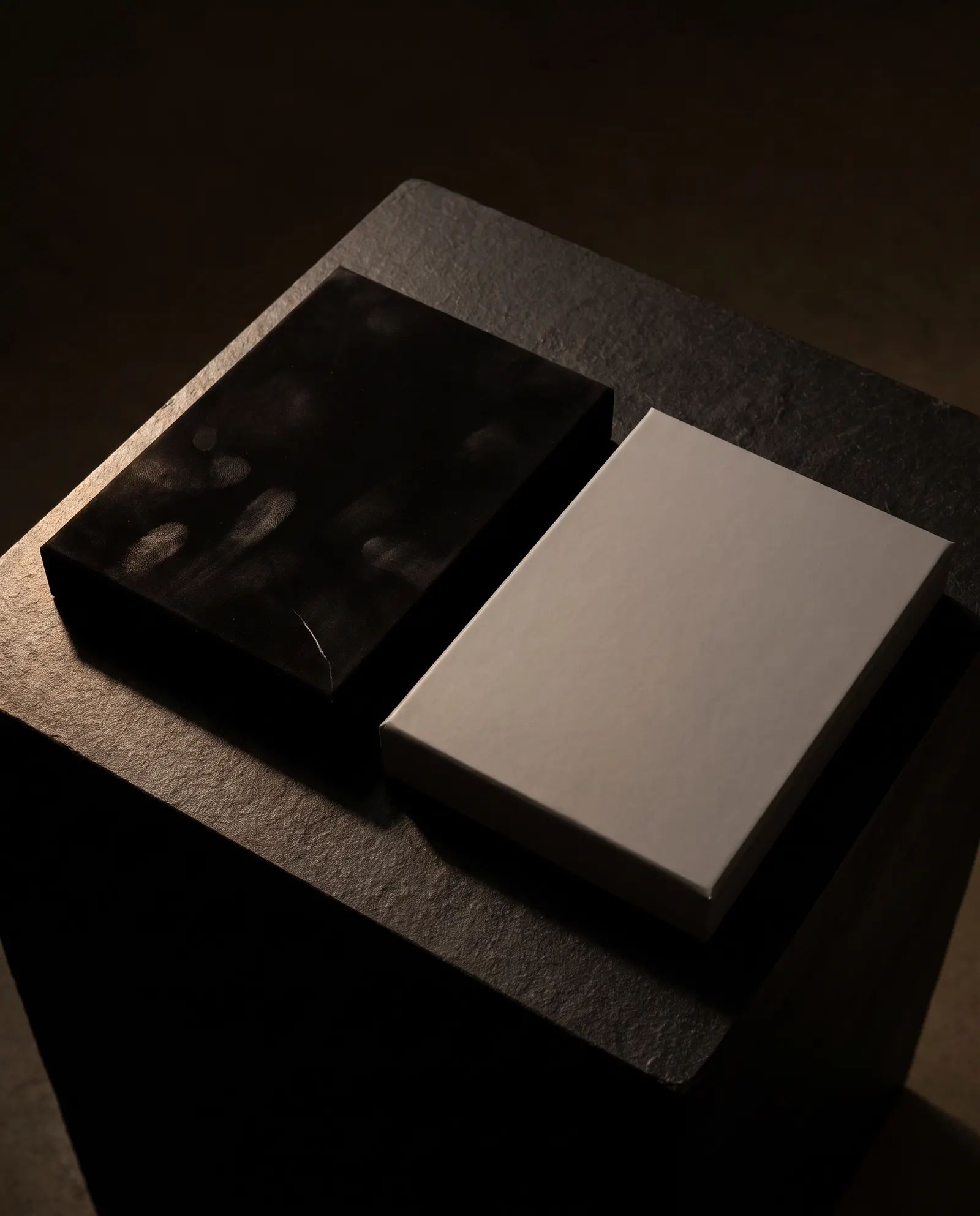 Black soft-touch box lid showing fingerprints and scuff beside clean grey soft-touch lid