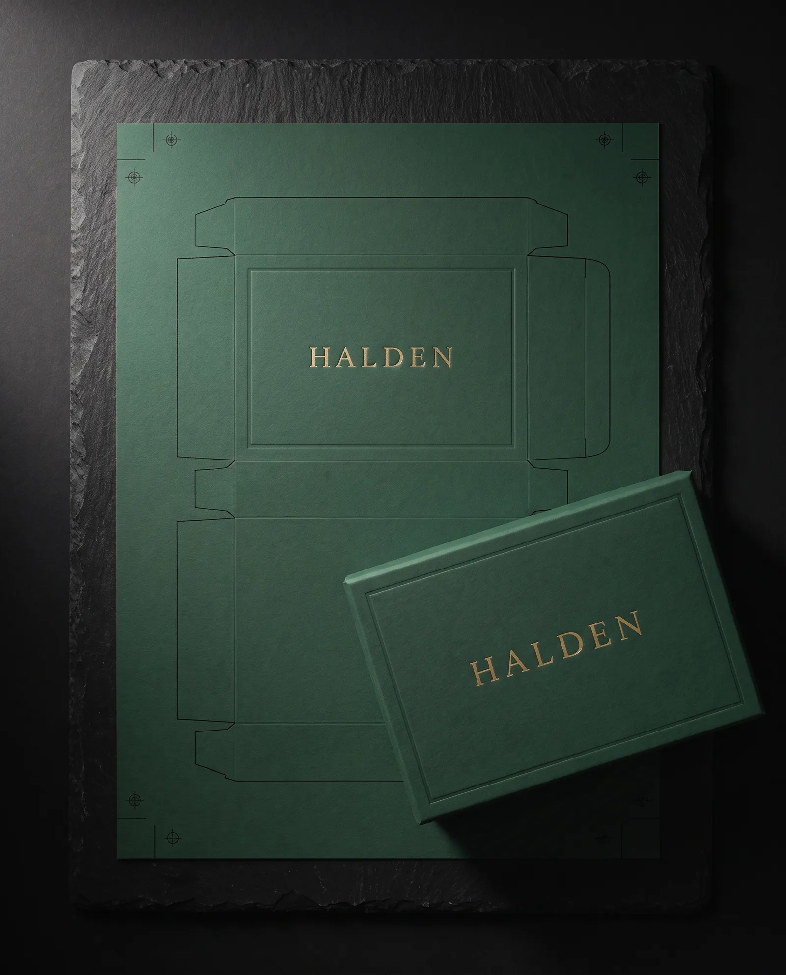 A printed box wrap laid flat on its dieline with crop marks, beside the finished box
