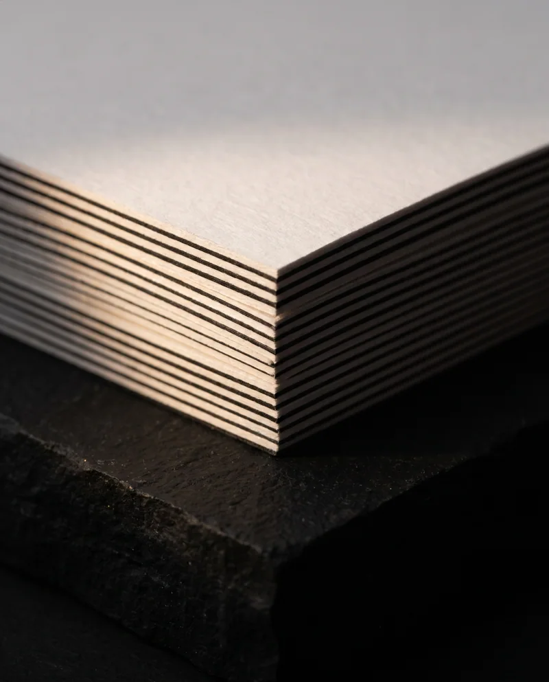 Macro of stacked 32pt triplex square business cards showing white and black layered edges