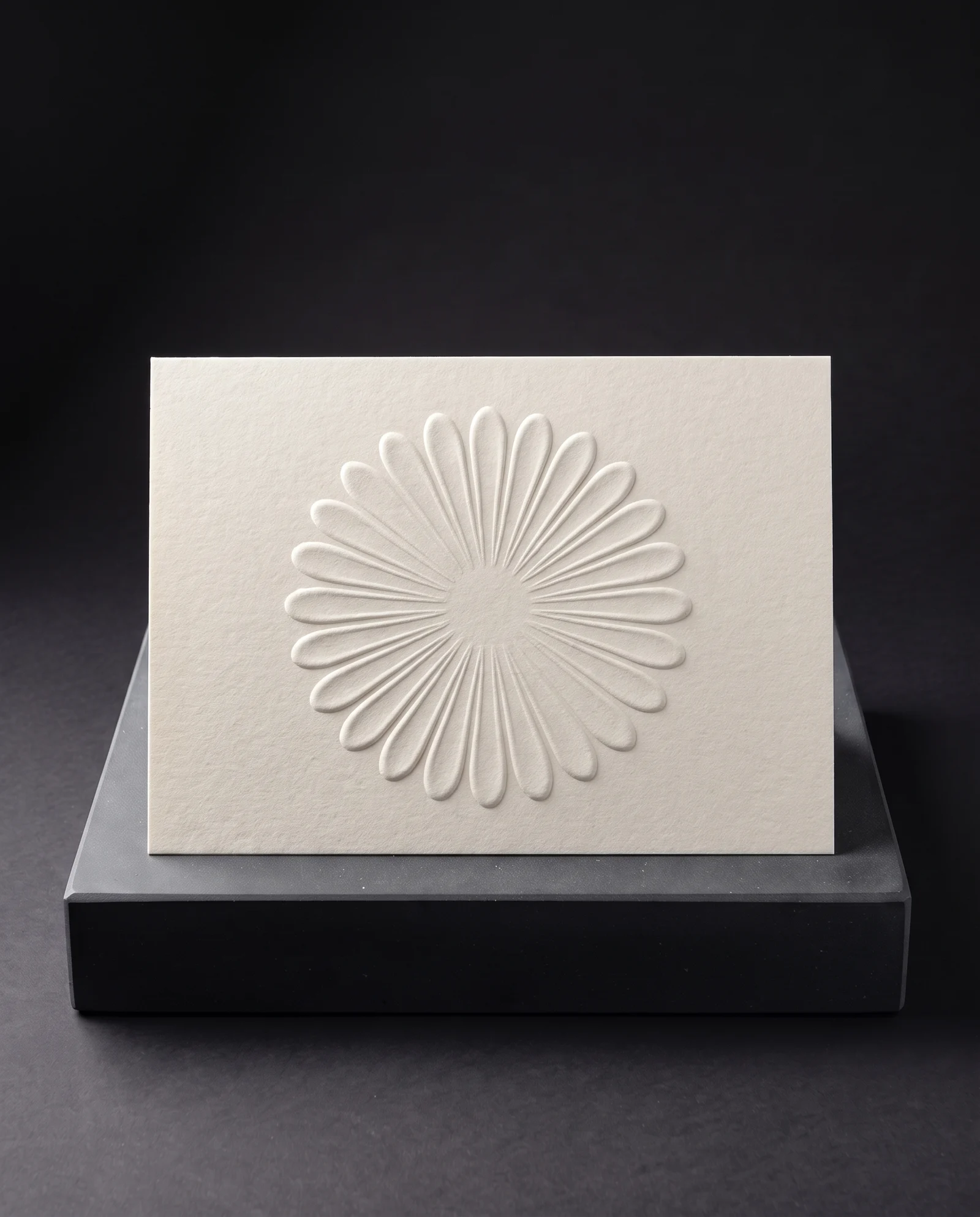 A raised blind emboss on cream heavy uncoated stock.