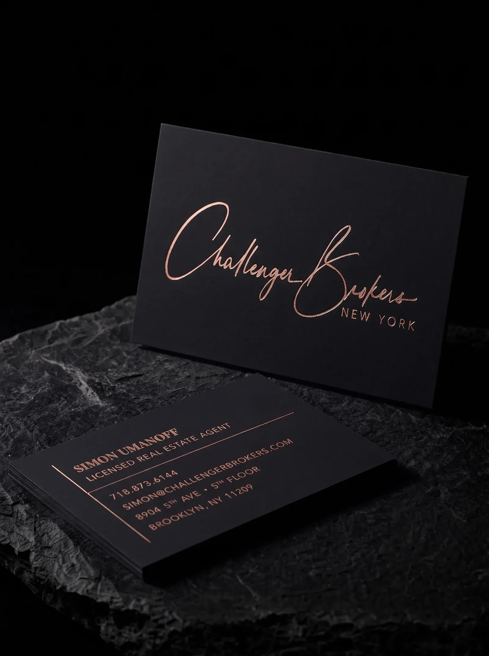 Challenger Brokers business cards: signature-script logo in rose gold foil on 48pt black soft touch