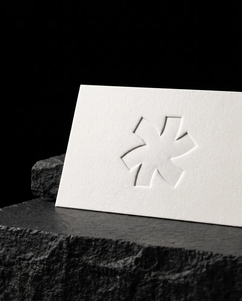 Blind deboss asterisk pressed into white cotton under grazing light