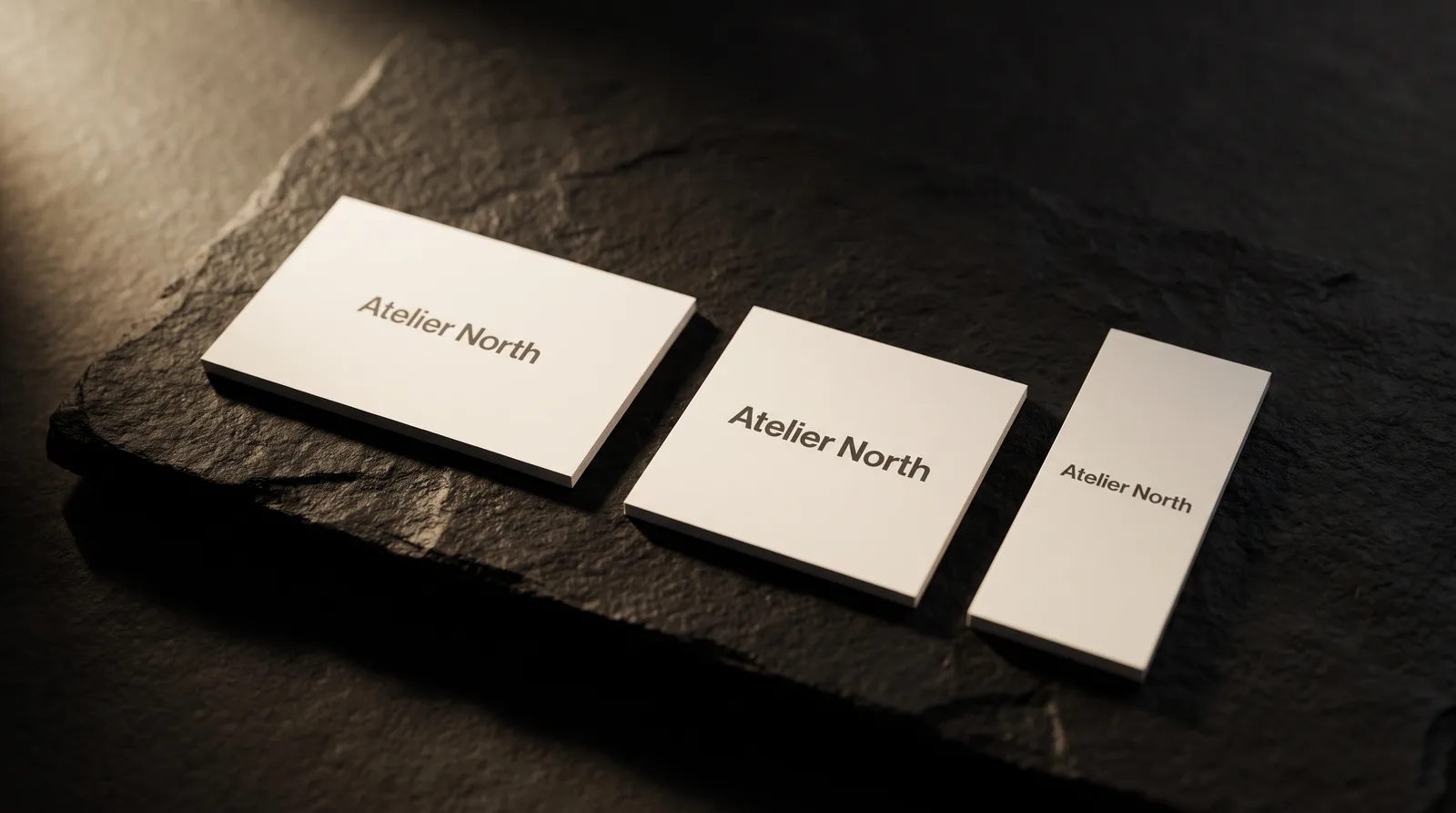 Standard, square and mini matte business cards side by side on black stone showing three sizes