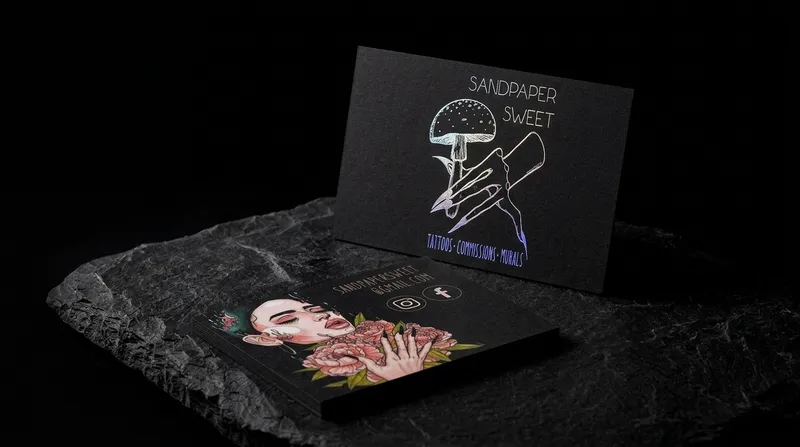 Tattoo artist business card with holographic foil linework on black and a colour painting on the back