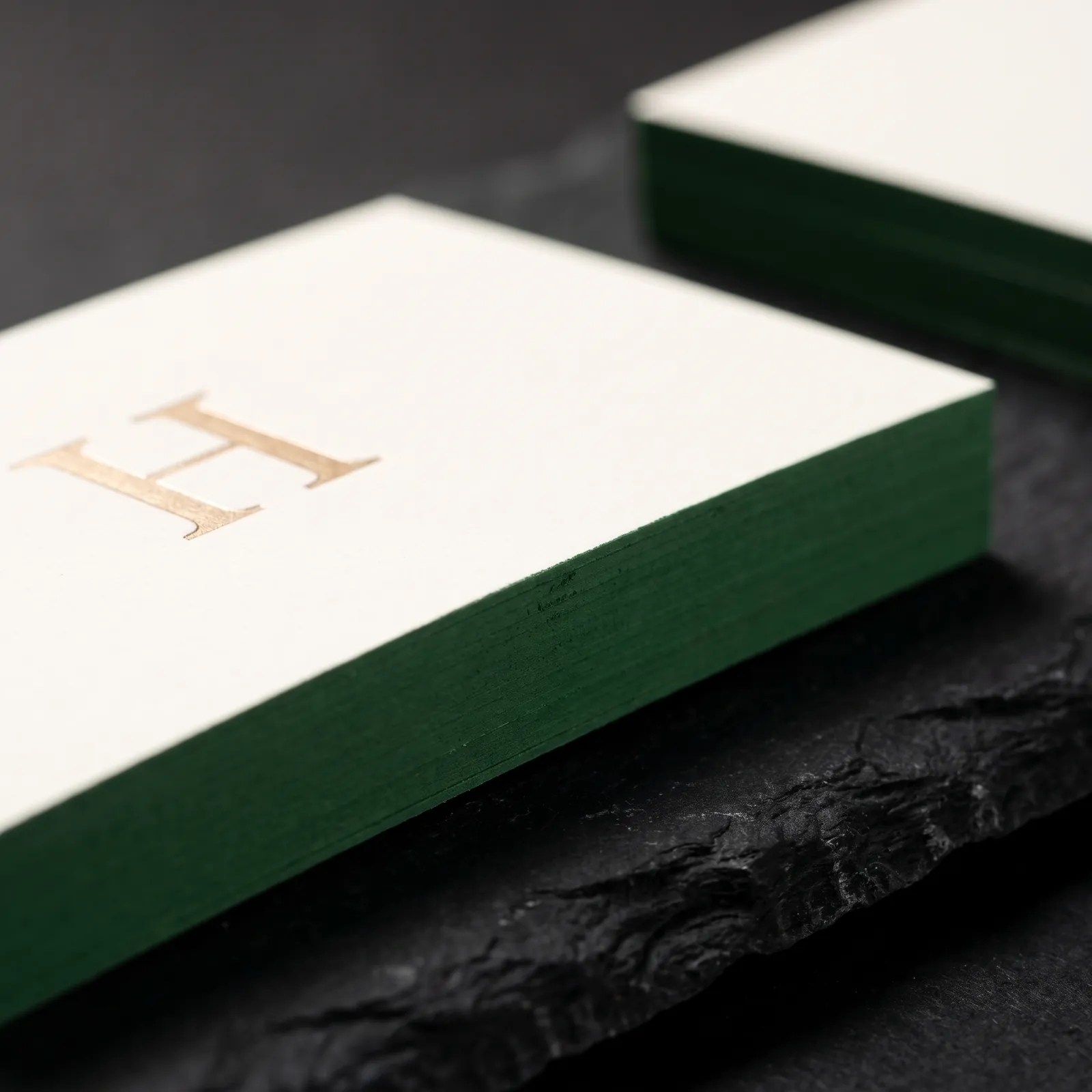 Thick ivory cotton card with its edge painted forest green