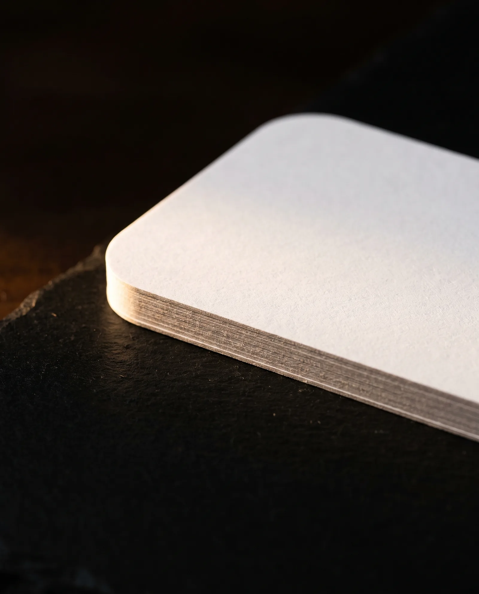 Close-up of a curved die-cut edge on a 32pt business card, showing a clean smooth cut