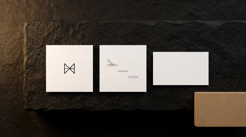 Front and back of a square white business card beside a standard rectangular card