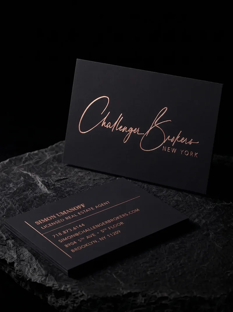 Thick black soft-touch business card with a rose gold foil signature logo