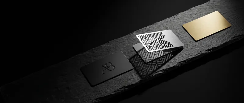 Black, silver and gold-tone metal business cards on a slate plinth