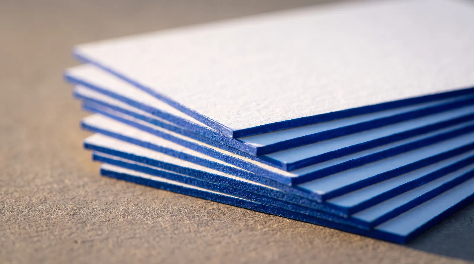 Edge paint needs thick board, square corners and a Pantone U reference, and it changes what your art can do near the trim. The rules, and why the clamped stack sets every one of them.