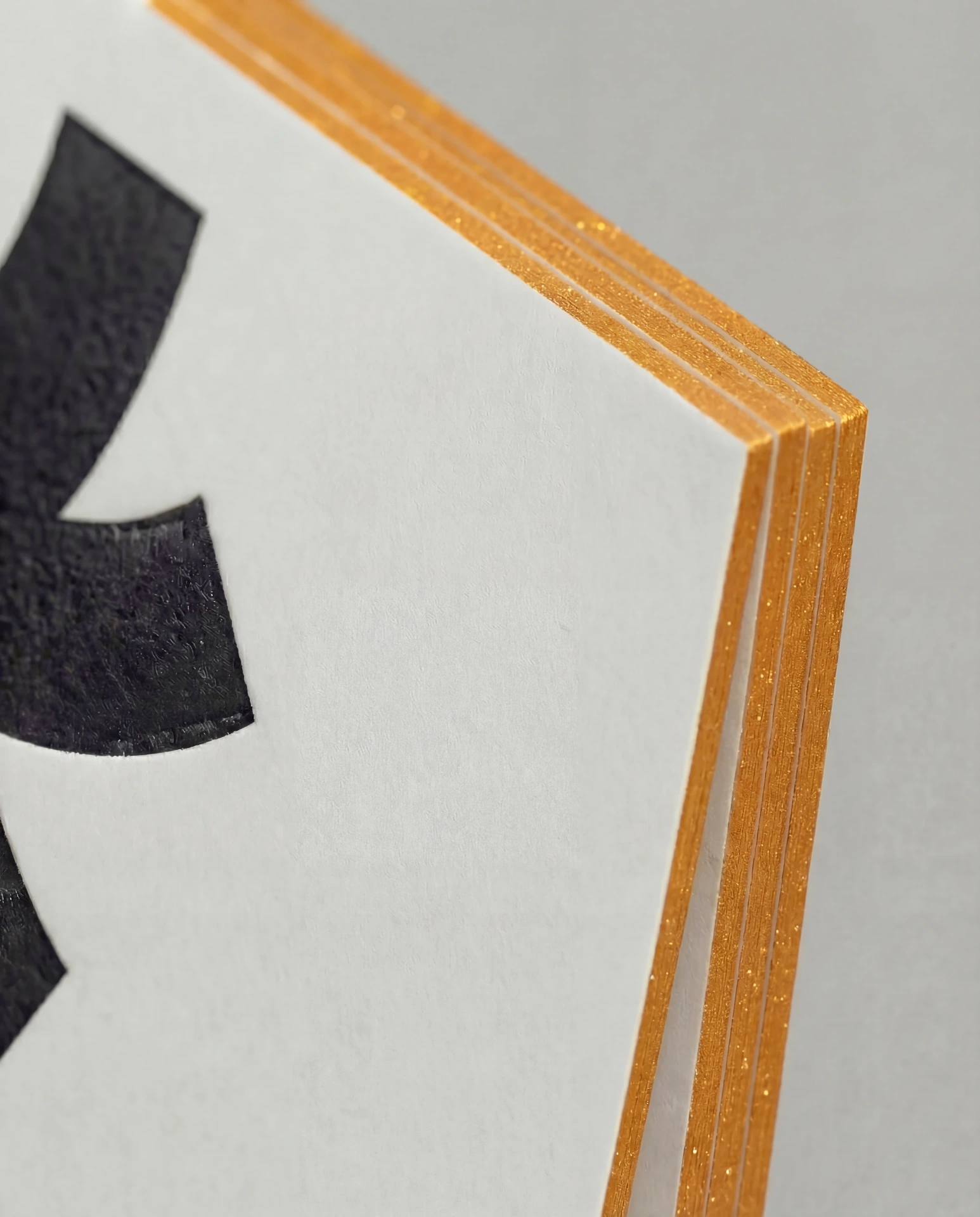 Metallic gold painted edge on a thick paper stack