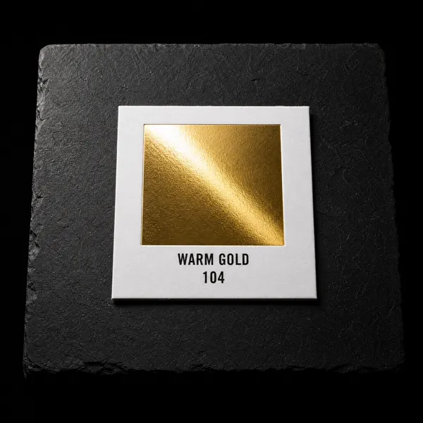 Warm Gold 104 foil chip photographed on slate