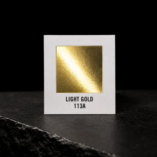 Light Gold 113A foil chip photographed on slate
