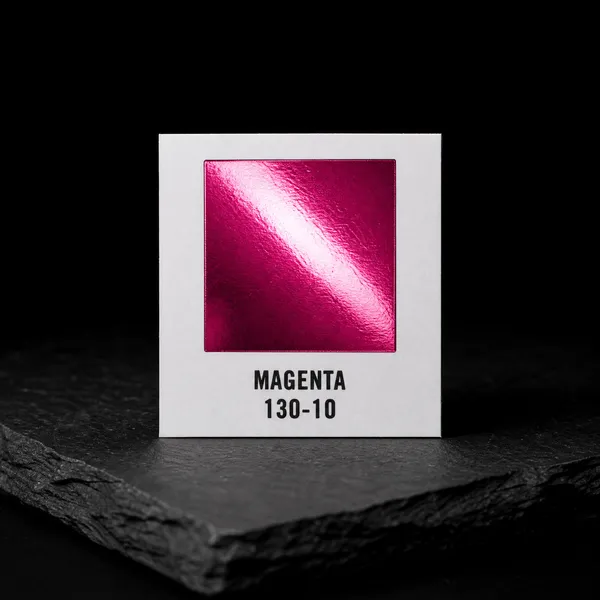 Magenta 130-10 foil chip photographed on slate