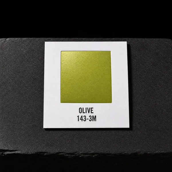 Olive 143-3M foil chip photographed on slate