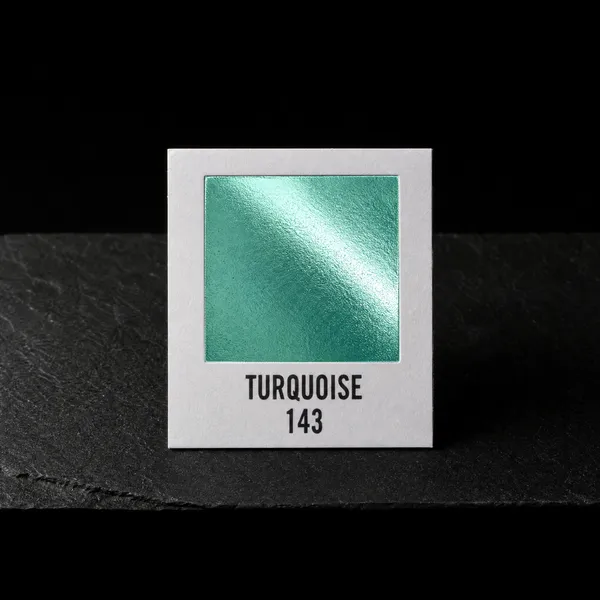 Turquoise 143 foil chip photographed on slate