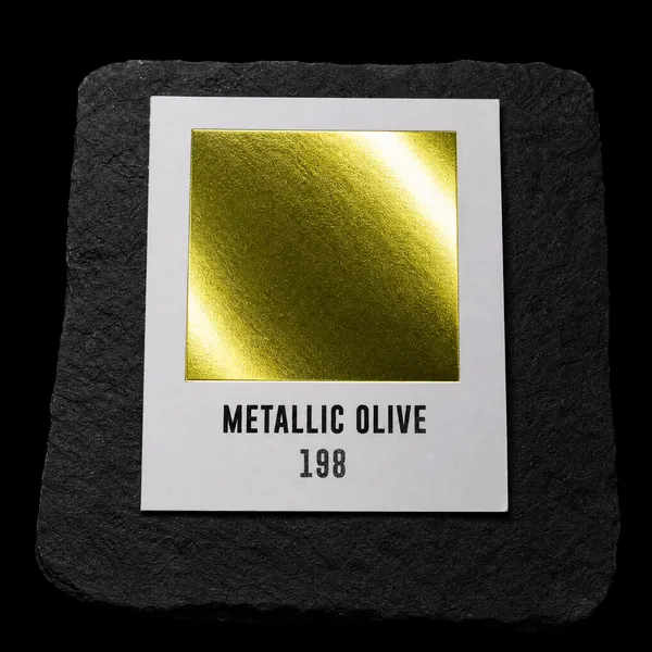 Metallic Olive 198 foil chip photographed on slate
